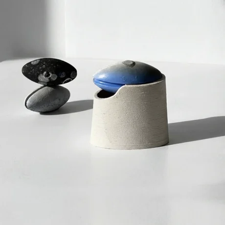3D printed float box in wood-based filament with blue lid on light surface