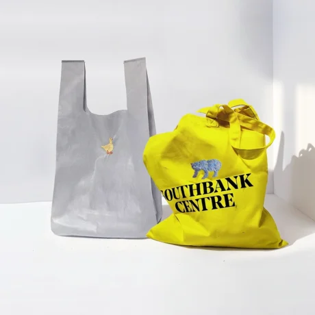 Embroidery kit displayed on two tote bags, showing the stitched motif together with its applied use.